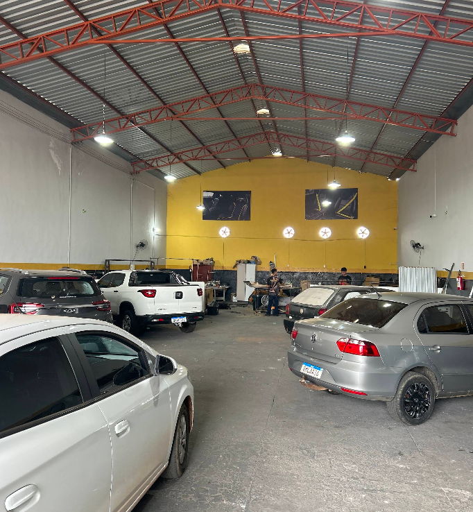 Interior amplo da oficina com vários carros em atendimento